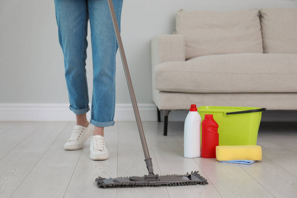 Woman washing floor with mop in living room, closeup - 写真・画像