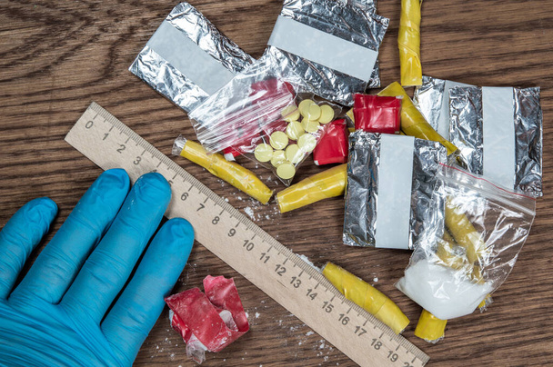 密輸の証拠:フォレンジックスケールの横にある未知の薬のパッケージ - 写真・画像