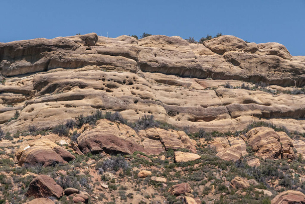 Los Padres National Forest, CA, USA - April 8, 2010: closeup of Brown stone top naked edge of flat mountain under blue sky. каміння й каміння між зеленою рослинністю.. - Фото, зображення