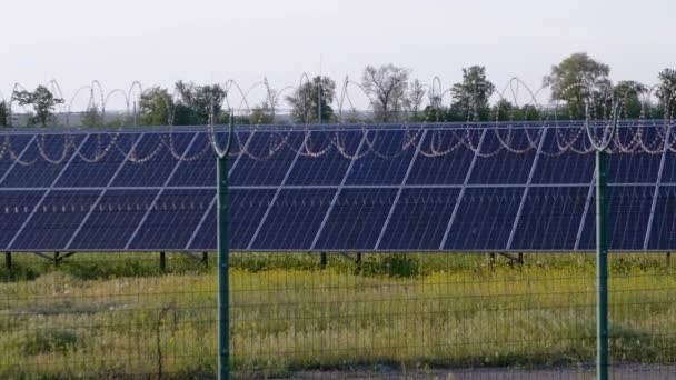 Panneaux solaires clôturés avec clôture en fil de fer barbelé. Piles solaires. Zoom - Séquence, vidéo