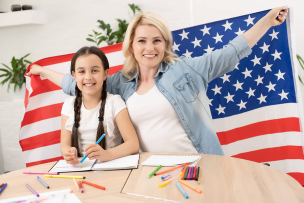 L'aiuto con i compiti è ampiamente richiesto tra gli scolari ora. Imparare l'inglese negli Stati Uniti. Studentessa inglese con la bandiera americana sullo sfondo - Foto, immagini