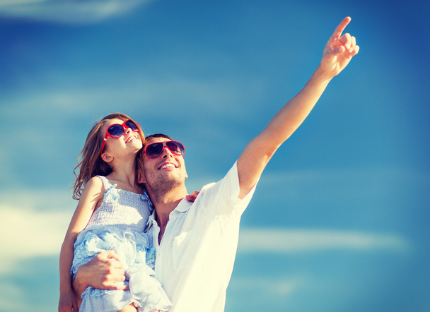 Gelukkig vader en kind in zonnebril over blauwe hemel - Foto, afbeelding