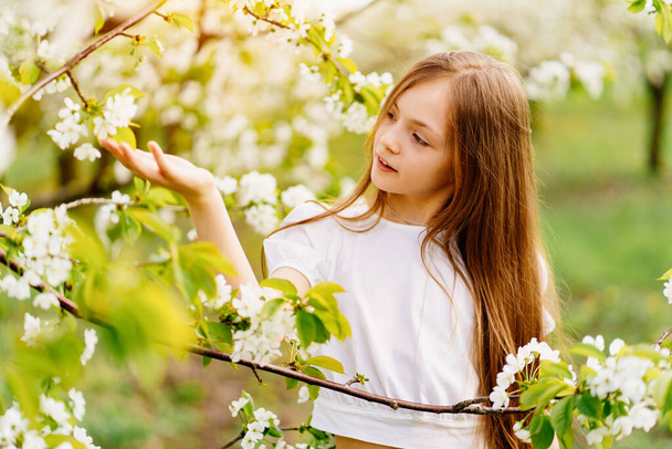 Beautiful teenage girl with a branch of a flowering tree. natural cosmetics - Photo, image