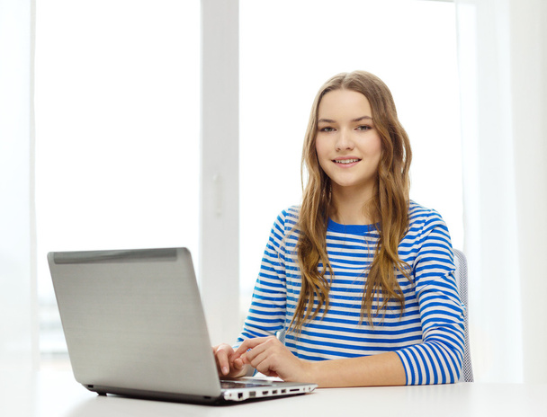 smiling teenage gitl with laptop computer at home - Photo, Image