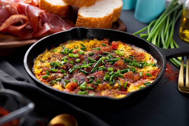 Egg omelet with sausage and seasonings in a cast iron pan close up, soft focus - Foto, immagini