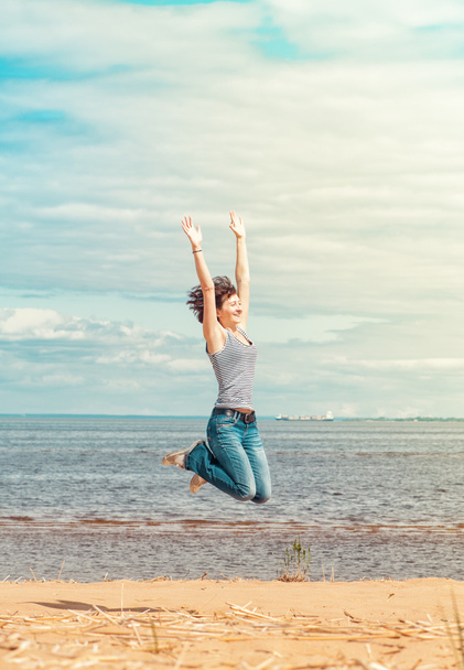счастливая женщина, прыгающая на пляже - Фото, изображение