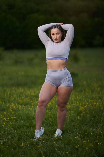 Plus size young beautiful runner woman posing in the forest - Foto, imagen