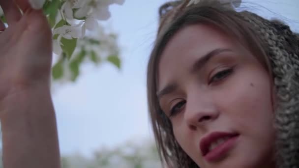 Una linda chica con rastas posa junto a un árbol con hojas - Metraje, vídeo