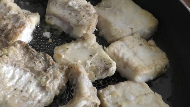 Κομμάτια μπακαλιάρου τηγανίζονται σε ένα τηγάνι. έννοια υγιεινής διατροφής  - Πλάνα, βίντεο
