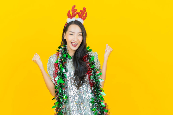 Portret mooie jonge aziatische vrouw dragen kerst outfit op gele achtergrond - Foto, afbeelding