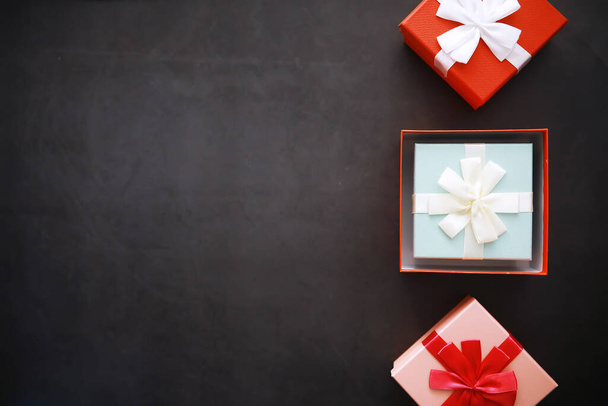Χριστουγεννιάτικη διακόσμηση. Κουτιά δώρων σε μαύρο φόντο πέτρα. Στο πάνω μέρος. Χριστούγεννα έννοια ευχετήρια κάρτα - Φωτογραφία, εικόνα