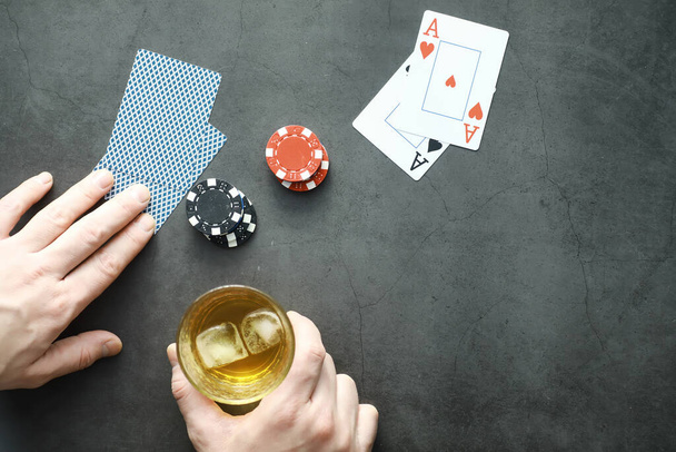 Uhkapeli Korttipelit rahasta. Texas Hold 'em pokeria. Kortit kädessä, pelimerkkejä, korttipakan alkoholin lasi. - Valokuva, kuva