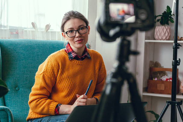 Vrouw coach of psycholoog voert online conferentie en neemt video op de camera voor blog thuis - Foto, afbeelding