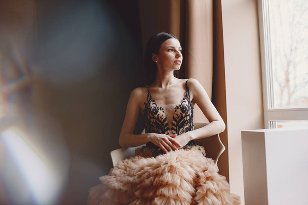 Beautiful woman model posing in elegant dress in the studio - 写真・画像