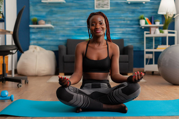 Retrato de mulher negra sorrindo praticando ioga em casa - Foto, Imagem