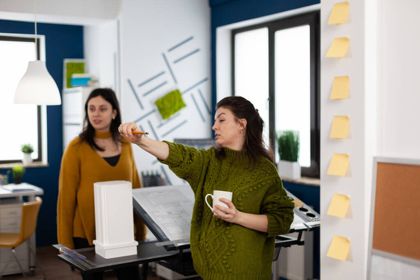 Equipe de mulheres arquitetas em pé no escritório agência criativa discutindo - Foto, Imagem
