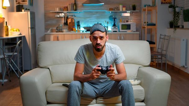 Focused man holding joystick while sitting in front of television - Photo, Image