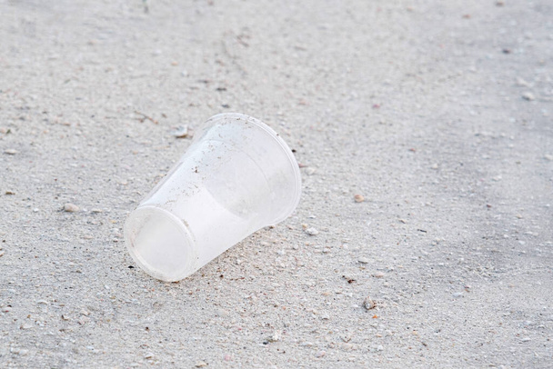 empty plastic disposable glass on beach, environmental pollution, issues - Photo, Image