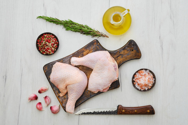 Overhead view of raw chicken thighs on wooden cutting board ready for cooking - 写真・画像