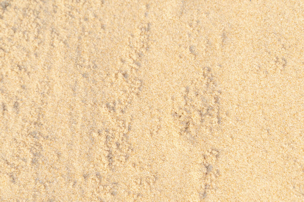 Písčitá textura pozadí na pláži. Světle béžové moře písek textura vzor, písečné pláže pozadí. - Fotografie, Obrázek