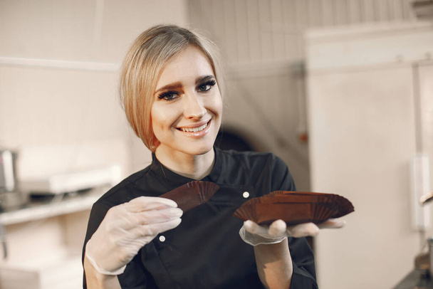 Confectioner pastry woman preparing eclairs and cupcakes - Foto, afbeelding