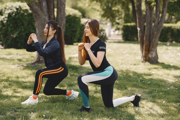 Cute girls doing yoga in a summer park - Фото, изображение