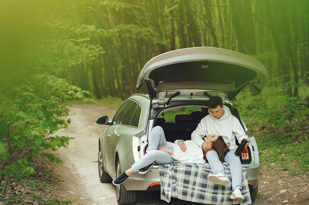 Couple in a forest sitting in a trunk - Φωτογραφία, εικόνα