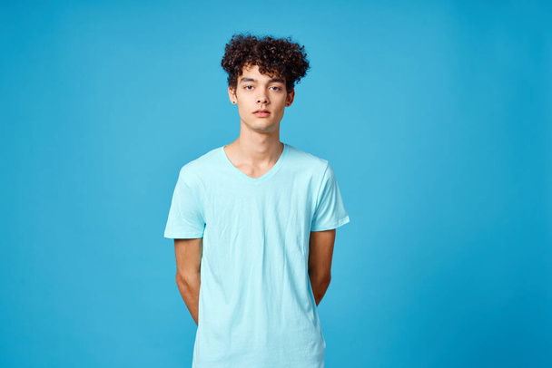 lindo chico rizado pelo azul camiseta aislado fondo - Foto, Imagen