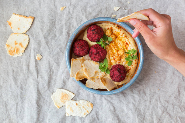 Kichererbsen-Hummus, Rote-Bete-Falafel mit Paprika, Olivenöl, Fladenbrot - Foto, Bild