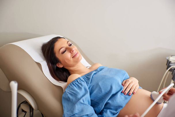 Pregnant woman with an ultrasound - Фото, зображення