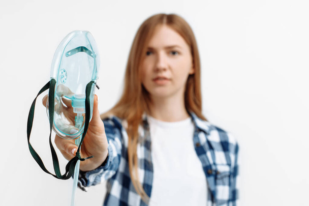 Portrait of young woman using oxygen mask, woman has difficulty breathing, treatment on isolated white background - Foto, imagen