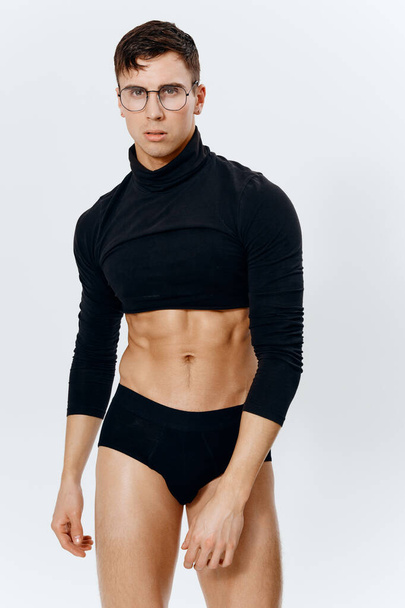 fisiculturista fitness homem esporte posando em um fundo leve e óculos no rosto  - Foto, Imagem