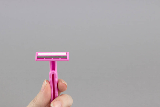 Pink lady shaver in hand. Hygiene skin body care concept - Photo, image