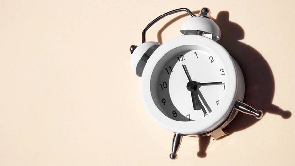 White vintage alarm clock with shadow - flat lay. - Φωτογραφία, εικόνα