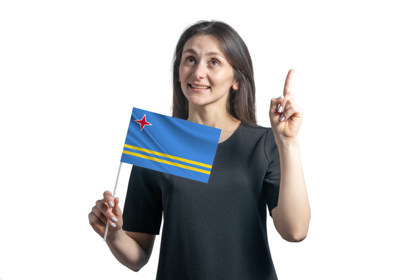 Happy young white woman holding flag of Aruba and points thumbs up isolated on a white background. - Photo, Image