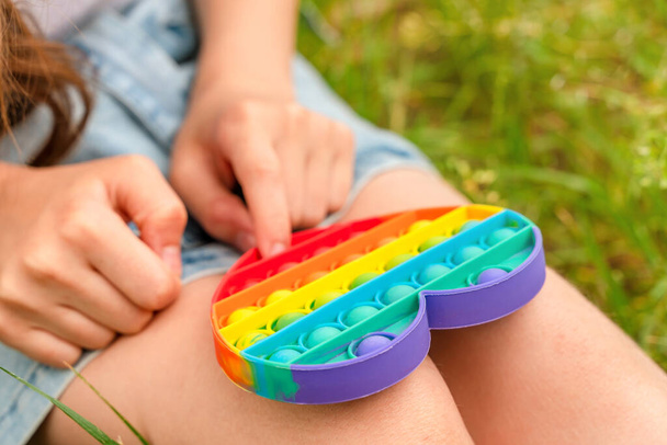 tiener meisje spelen met populaire siliconen kleurrijke antistress pop het speelgoed - Foto, afbeelding