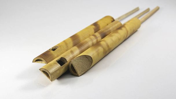 Pár malých bambusových flétn. populární hračka dárek pro děti se sladkými zvuky. Hudební Ptačí volání Zvuková Píšťalka. Flétna Imitator Bird Sound. Zatímco fouká, vytáhněte bambusovou tyčinku sem a tam. - Fotografie, Obrázek