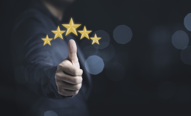 Pouce main homme d'affaires lever avec des étoiles jaunes pour la satisfaction de la clientèle et le concept d'évaluation du service produit.  - Photo, image