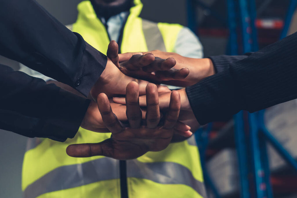 Trabajadores de la fábrica apilando manos juntos en almacén o almacén - Foto, imagen