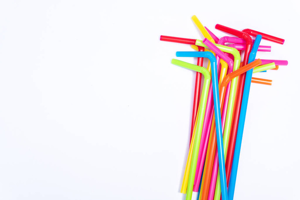 Top view plastic straws on white background with copy space for design, stop using plastics garbage for environment concept - Foto, Imagen