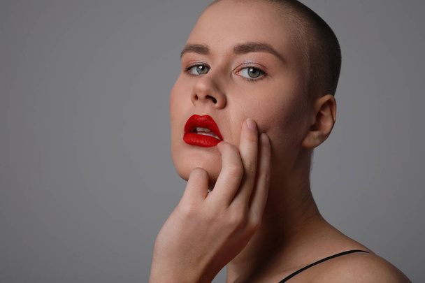 Headshot of beautiful bald woman with red lips, isolated over white wall. - Fotó, kép