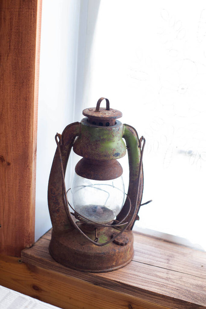 Old metal kerosene lamp on the window. Museum exhibit, close-up, old-fashioned - Fotografie, Obrázek