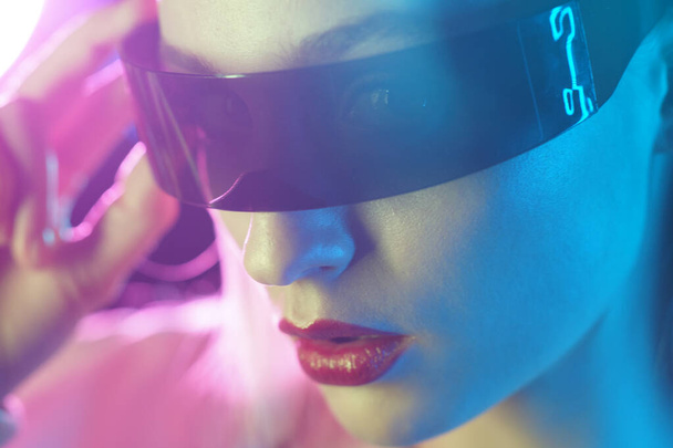 Portrait of a beautiful and young girl in cyberpunk style. Mixed color light effect. Futuristic concept. - Foto, Bild