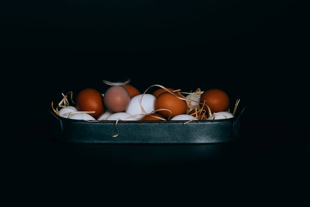 Chicken eggs in vintage tray on a black background. Organic, biological, bio products, bio ecology, healthy. - Fotó, kép