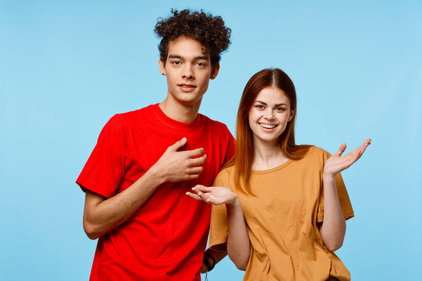 веселая молодая пара разноцветные футболки современный стиль моды синий фон - Фото, изображение