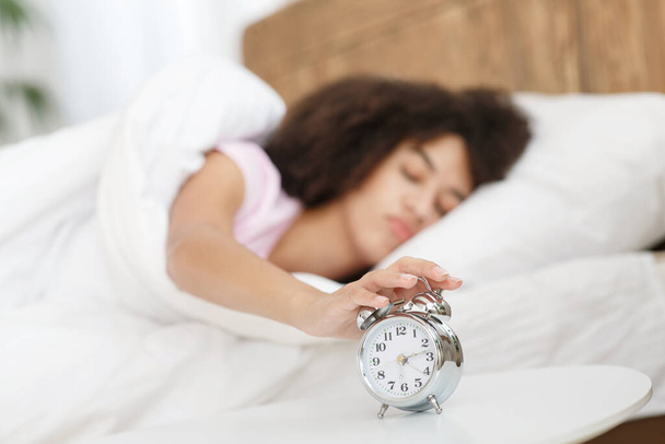 Lady turns off alarm clock, waking up in morning from call - Photo, Image