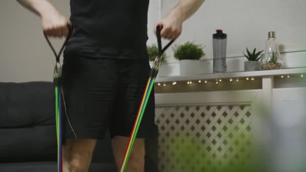 Man doing exercises with resistance bands at home. - Footage, Video