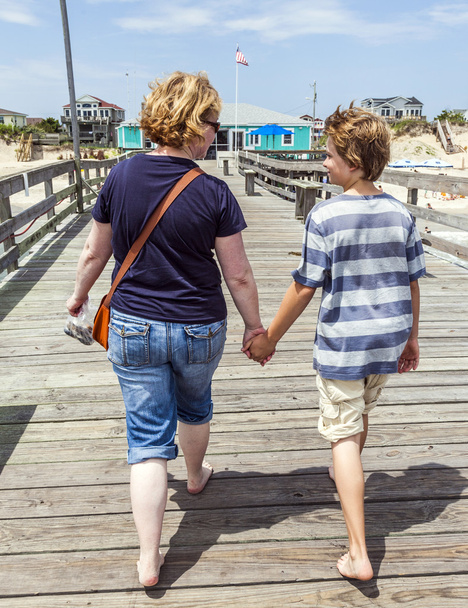 μητέρα και γιος περπάτημα χέρι-χέρι στο διάσημο τα pier - Φωτογραφία, εικόνα