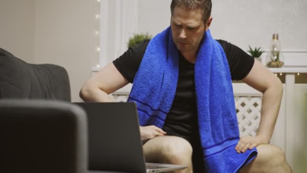 男はノートパソコンで運動を見ている。自宅でのスポーツ活動. - 映像、動画
