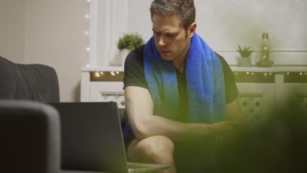 男はノートパソコンで運動を見ている。自宅でのスポーツ活動. - 映像、動画